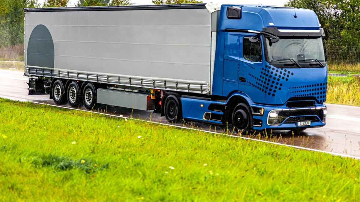 Niebieska ciężarówka z naczepą na drodze