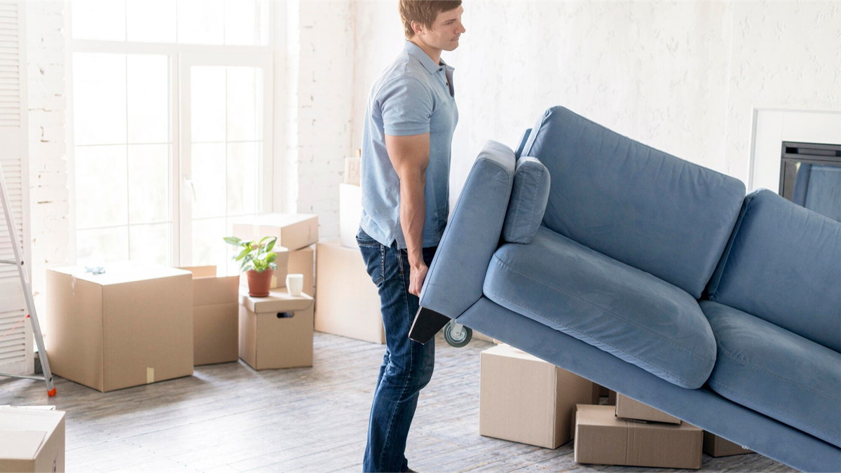 mężczyzna trzymający kanapę