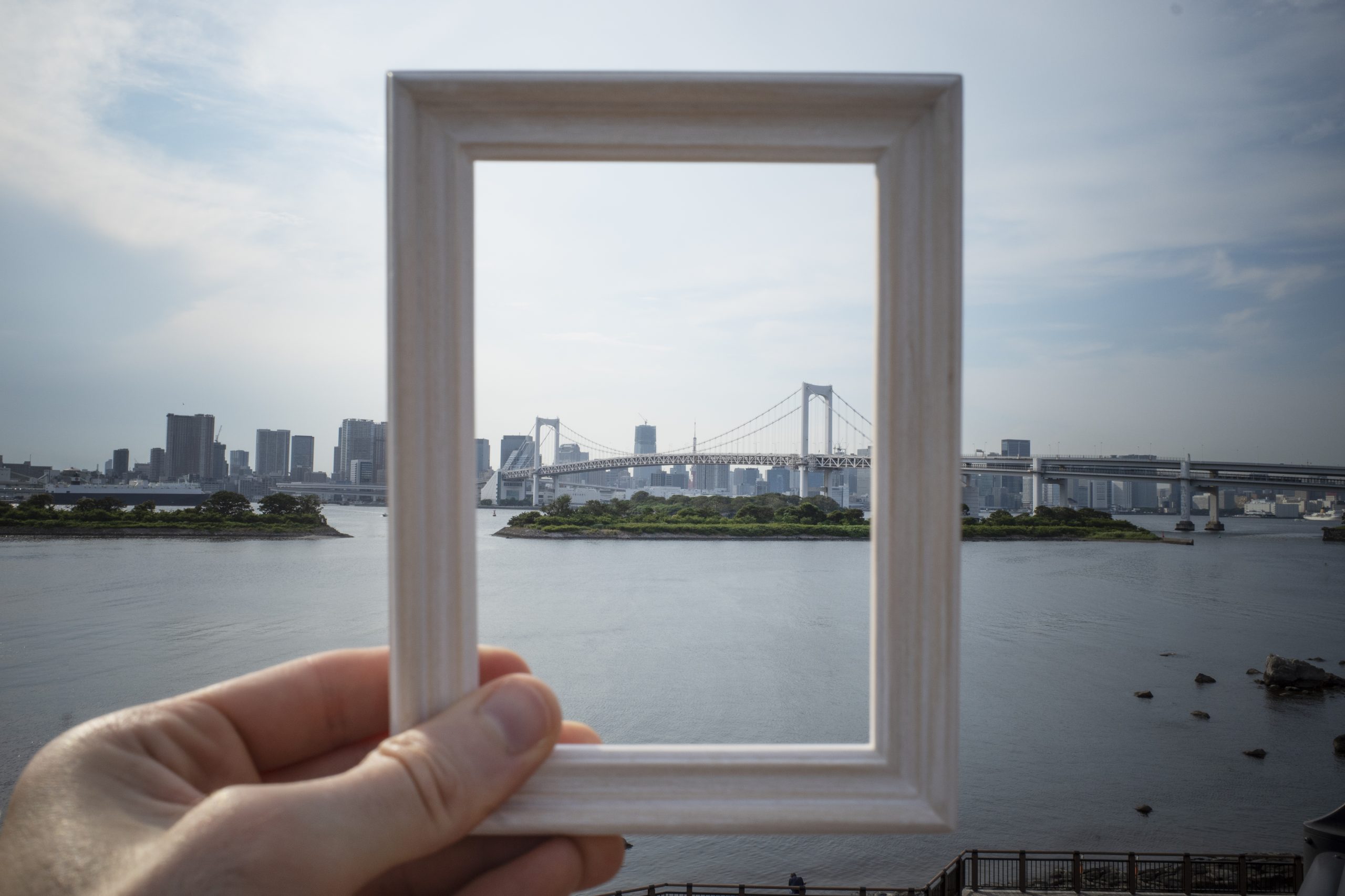 osoba trzymająca małe lustro i patrząca przez nie